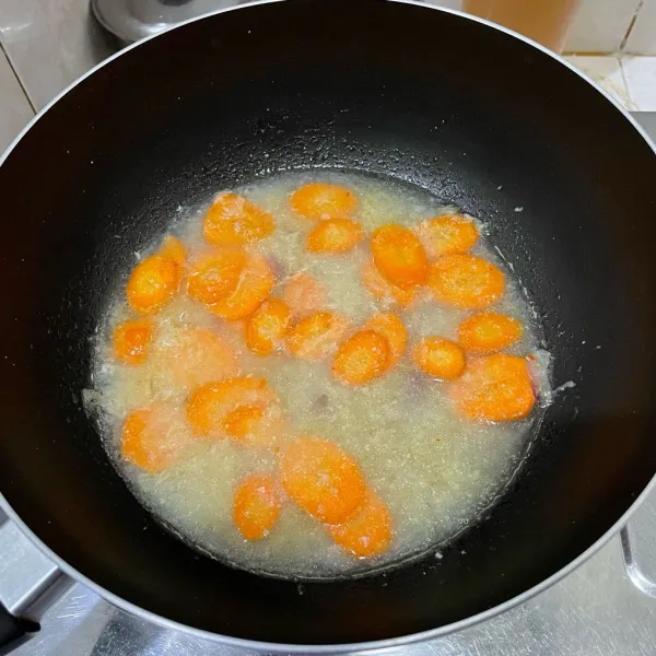Masukkan wortel, aduk-aduk sebentar, lalu tuang air. Masak sampai wortel empuk.