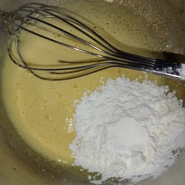 Aduk rata kuning telur dan gula hingga tercampur rata seperti pasta kemudian masukkan tepung maizena.