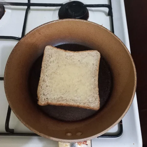 Panggang roti dengan api kecil di atas teflon.
