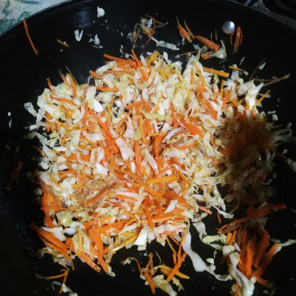 Masukkan wortel, kol, garam, lada bubuk dan kaldu bubuk. Masak hingga sayur layu.