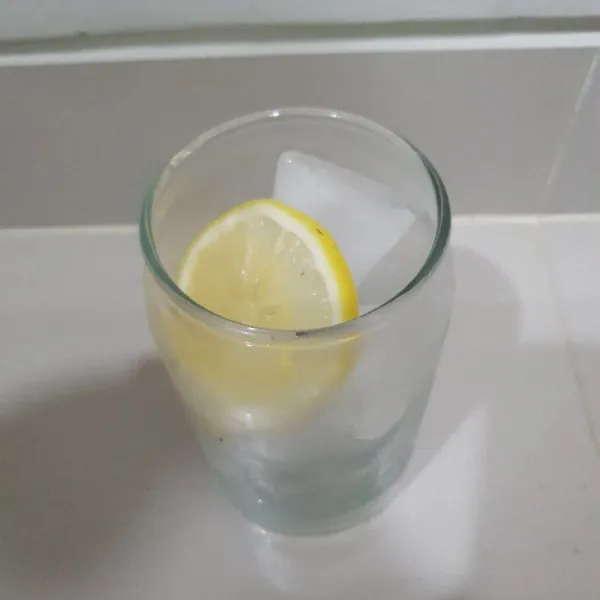 Lalu masukan 75 gr es batu ke dalam gelas dan 2 buah irisan lemon.