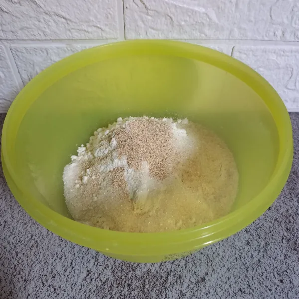 Campurkan tepung terigu, gula pasir, ragi instan, dan vanili. Aduk sampai rata.