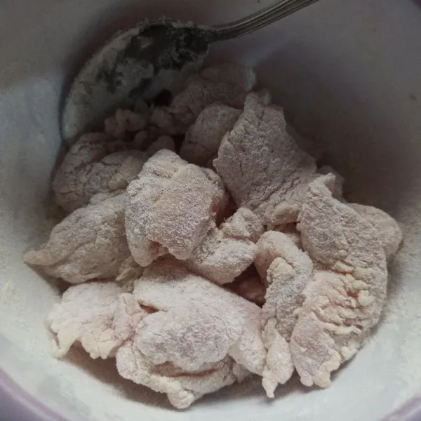 Potong-potong ayam fillet kemudian tambahkan tepung bumbu aduk hingga tercampur rata kemudian diamkan selama 10 menit.