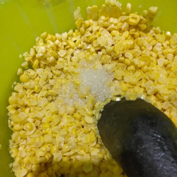 Sisir jagung menggunakan pisau beri gula pasir kemudian  di ulek asal agar pada saat ngegoreng tidak meledak.