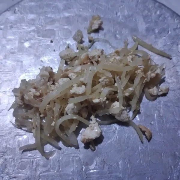Tata bahan isian di atas rice paper, gulung seperi membuat lumpia.