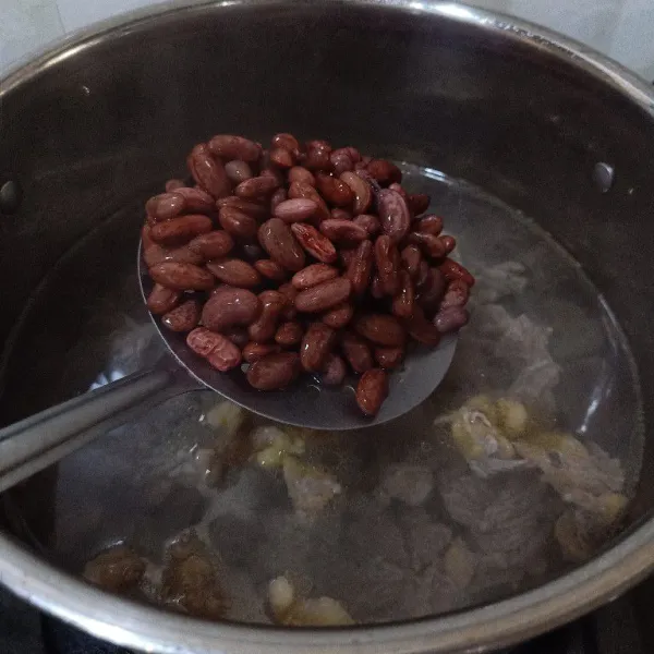 Masukkan kacang merah ke dalam air rebusan daging.