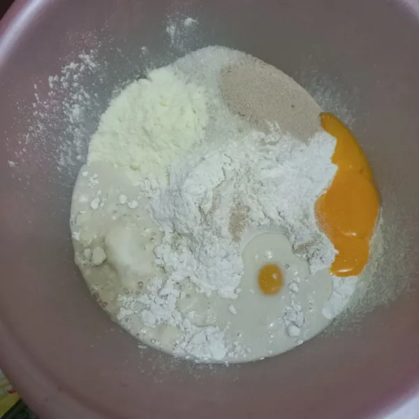 Dalam wadah campur tepung terigu, susu bubuk, kuning telur, gula pasir, ragi instan, susu cair dan air secukupnya ,uleni hingga rata.