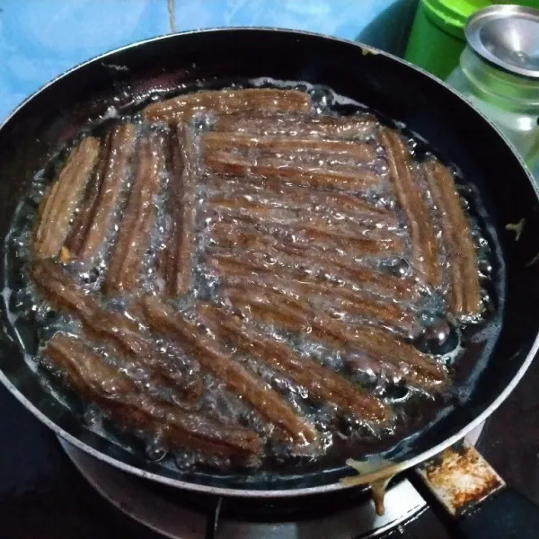 Siapkan piping bag, masukkan adonan lalu spuit adonan di atas minyak, goreng churros sampai matang, semua sisi garing. Sajikan dengan saus coklat atau selai.