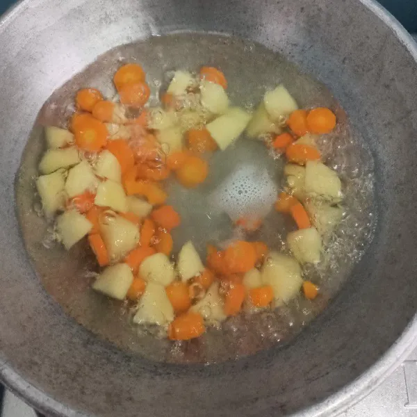 Setelah mendidih masukkan kentang dan wortel.
