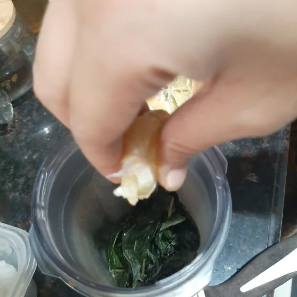 Masukan bawang putih dan daun basil dalam blender.
