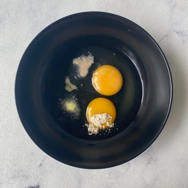 Campurkan telur, garam, kaldu bubuk, bawang putih bubuk dan merica bubuk ke dalam mangkuk.