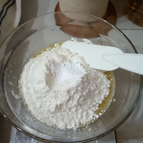 Dalam wadah telur. Masukkan tepung dan baking soda. Aduk hingga tercampur merata ya.