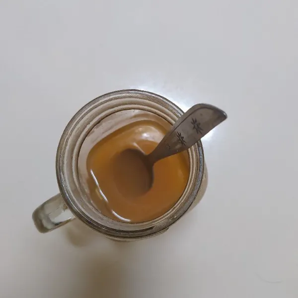 Larutkan serbuk minuman instan rasa orange, gula pasir dengan air hangat.