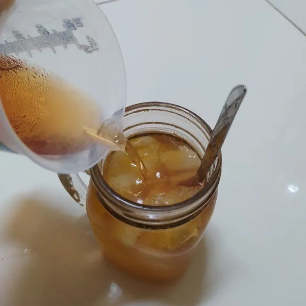 Tambahkan es batu dan air teh.