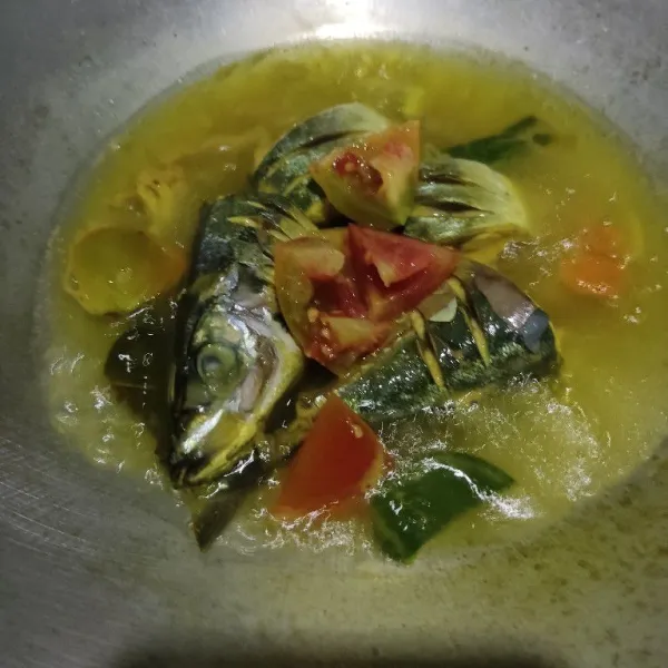 Masukkan tomat, aduk dan masak hingga ikan matang.