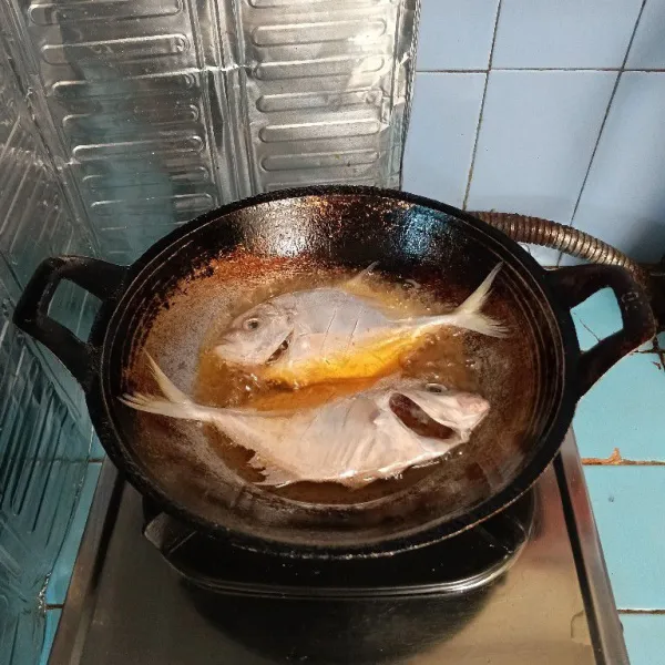 Panaskan minyak, goreng ikan sampai setengah matang.