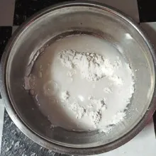 Masukkan tepung beras ke wadah dan beri 500 ml air dalam suhu ruang, aduk.