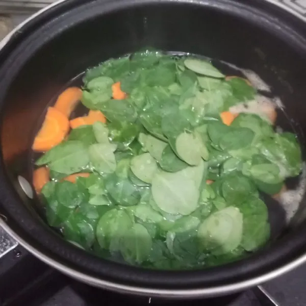 Matikan kompor masukkan daun kelor, kemudian tutup agar kandungan gizi dalam daun kelor masih bagus. Biarkan kurang lebih 10 menit, angkat dan sajikan.