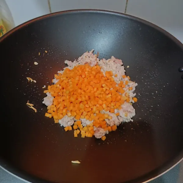 Kemudian masukkan wortel dan ayam cincang, aduk hingga ayam berubah warna kemudian beri air. Masak hingga wortel empuk dan ayam matang.