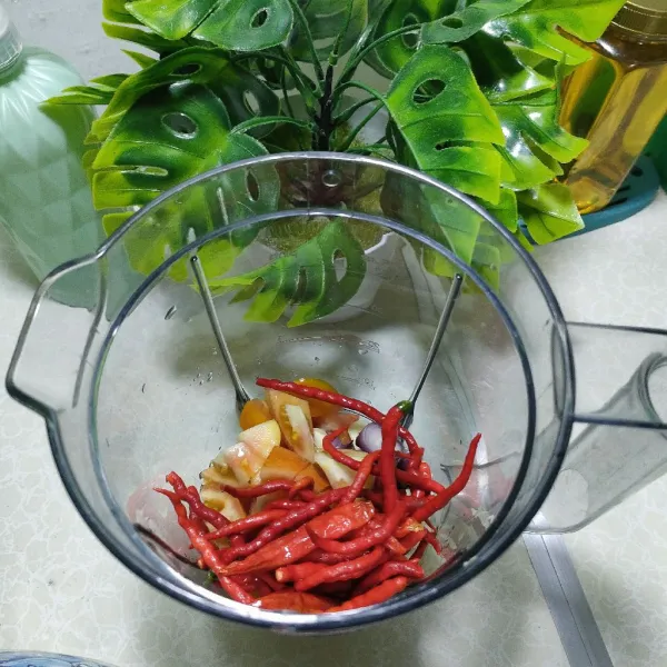 Potong tomat, lalu blander bahan yang di haluskan, bawang merah, bawang putih, cabe, kemiri.