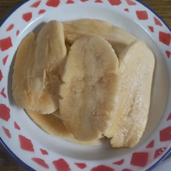 Kupas pisang kemudian pipihkan.