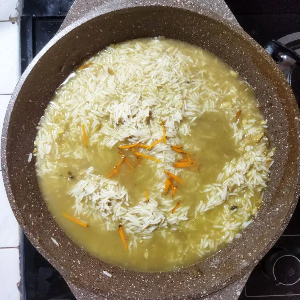 Membuat nasi mandhi, masukkan beras basmati yang telah direndam kedalam panci ungkepan ayam. Tambahkan air hingga beras terendam air. Saffron atau diganti tambahkan kunyit yang diiris tipis panjang, dan aduk rata. Kemudian masak nasi hingga air hampir meresap semua. Angkat dan tunggu air meresap sempurna.