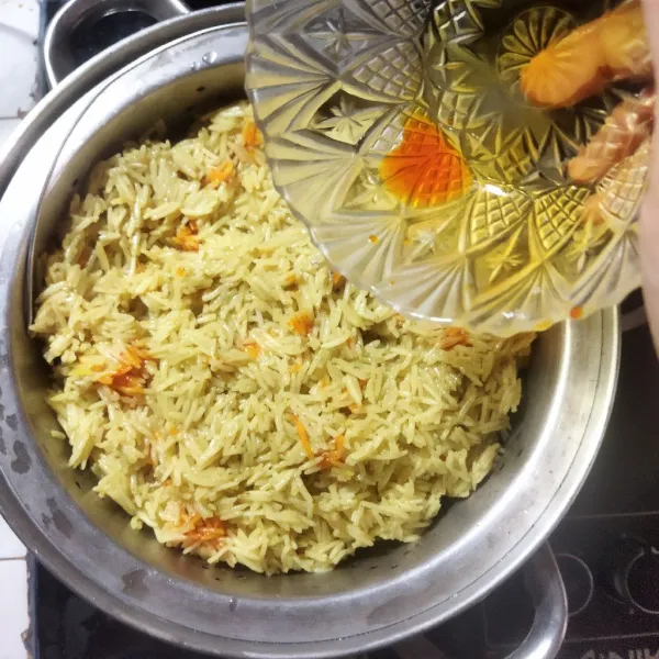 Masukan nasi karon ke dalam kukusan, tuang pewarna sesendok demi sesendok dengan acak. Masak nasi hingga matang selama 25 menit hingga matang. Angkat