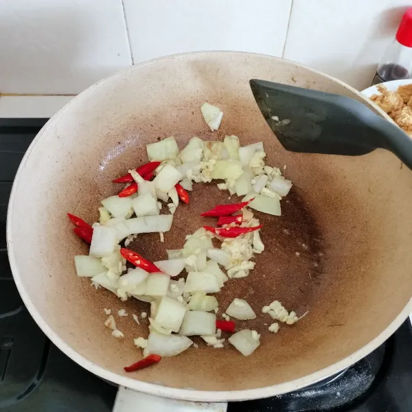 Panaskan minyak, tumis bombay sampai layu lalu masukkan bawang putih dan irisan cabai, tumis sampai harum.