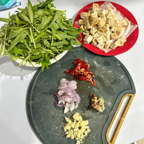 Siapkan semua bahan. Siangi kangkung, goreng tahu dan potong-potong, iris bawang-bawang dan cabe, geprek lengkuas.