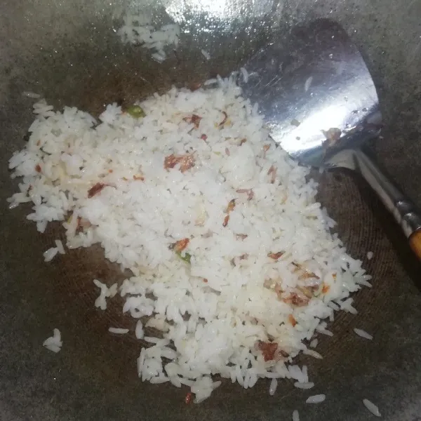 Kemudian masukan nasi, aduk sampai merata lalu beri secukupnya garam dan penyedap rasa
