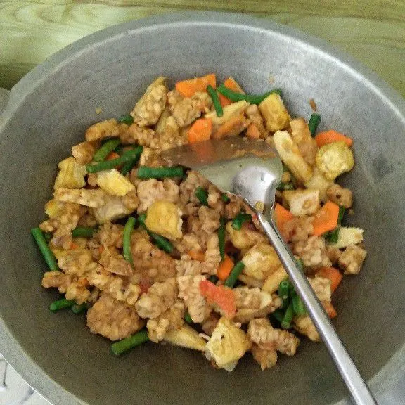 Masukkan kacang panjang, wortel, jagung putren, air lalu aduk. Masak sampai empuk. Masukkan tahu dan tempe.