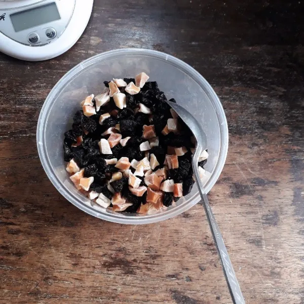 Potong kecil-kecil kismis dan manisan pepaya.