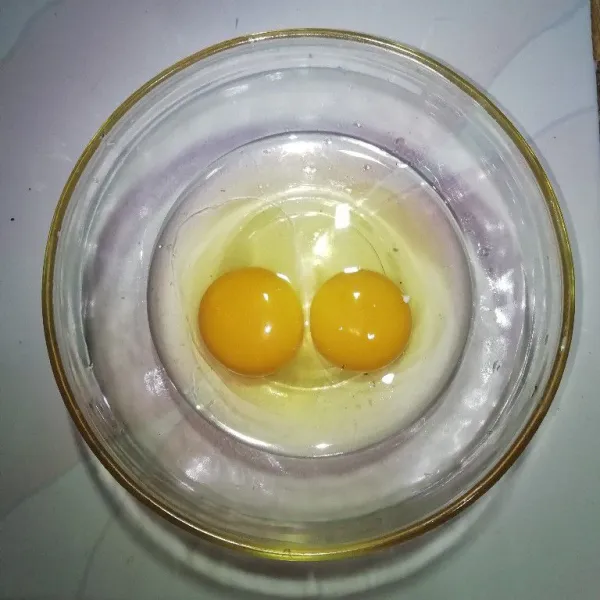 Siapkan 2 butir telur ayam.