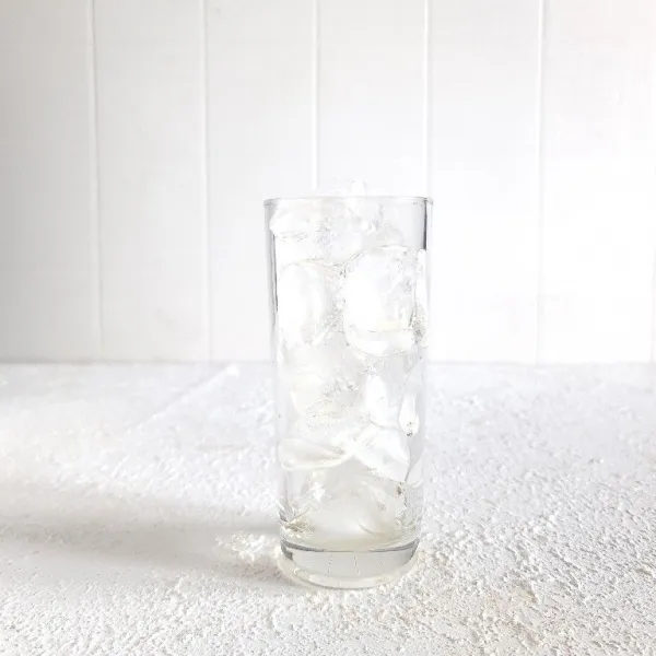 Tuang es batu ke dalam gelas.