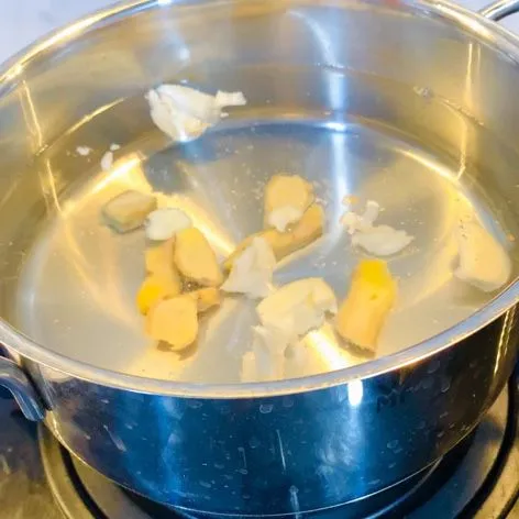 Masukkan jahe dan bawang putih pada air.