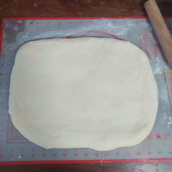 Di sini saya timbang sebanyak 693 gr sesuai dengan loyang saya ukuran 25x12x12cm. Sisanya bisa dijadikan roti yang lain. Bulatkan adonan. Istirahatkan adonan selama 15 menit.
Pipihkan dengan rolling pin.