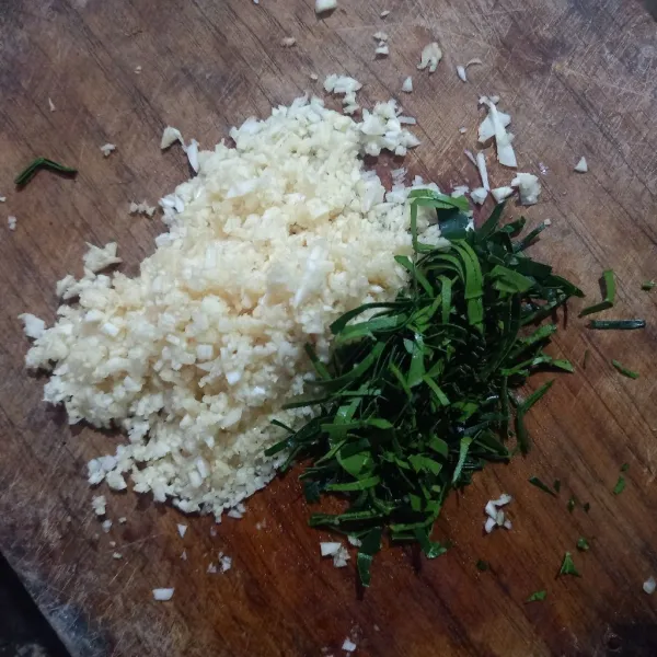 Iris tipis daun jeruk dan cincang halus bawang putih, kemudian goreng sampai kering.