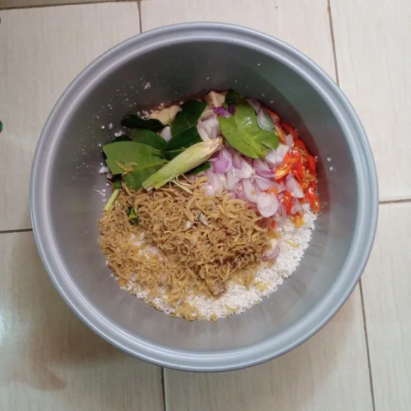 Cuci bersih beras, masukan dalam mejicom, lalu masukan teri, salam, sereh, cabe dan bawang.