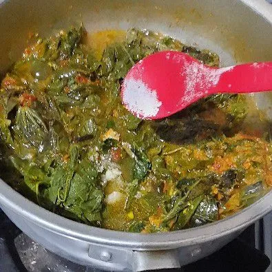 Lalu masukkan daun singkong tambahkan garam, gula dan kaldu bubuk, masak hingga daun singkong lunak.