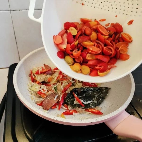 Masukkan kulit melinjo & tomat, tuang sedikit air dan saus tiram. Aduk rata.