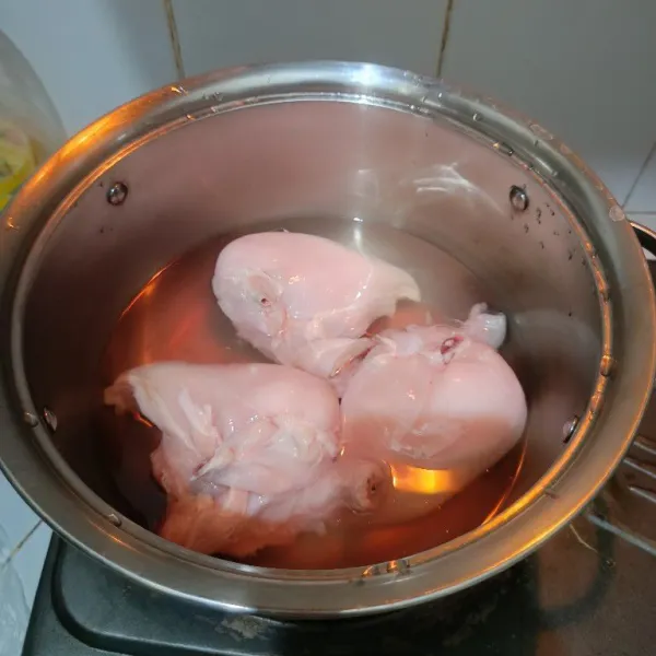 Cuci bersih ayam, kemudian rebus hingga daging ayam matang.