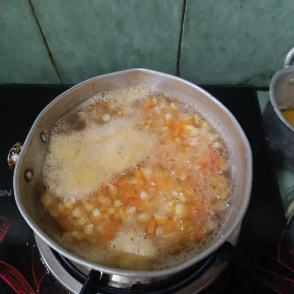 Siapkan panci, isi dengan air, lalu masukkan  wortel yang telah di cincang kecil berbentuk kotak, dan jagung yang telah dipipil. Kemudian rebus kedua sayuran hingga setengah matang. Angkat, lalu sisihkan.
