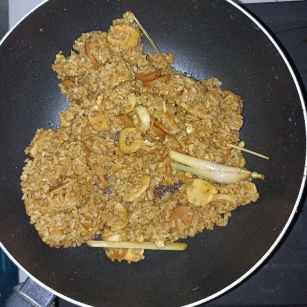 Masak nasi goreng sampai bumbunya merata. Koreksi rasa dan angkat. Sajikan.