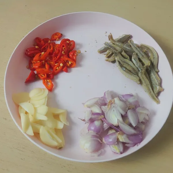 Siapkan bumbu: iris bawang merah, bawang putih, dan cabai.
