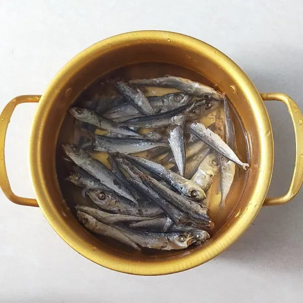 Siapkan ikan asin rebus lalu rendam dengan air hangat selama 5 menit, lalu cuci bersih dan tiriskan.