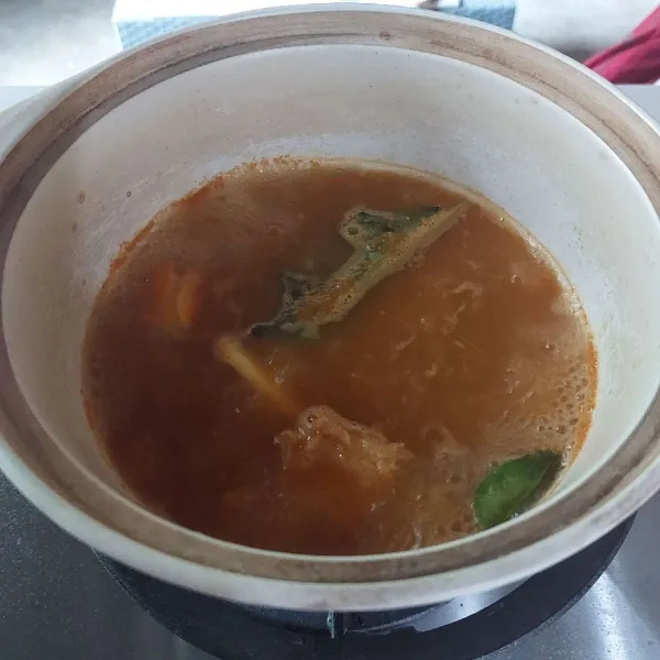 Campur bumbu halus, bumbu geprek, daun jeruk dan daun salam dengan 500 ml air, masak sampai mendidih.