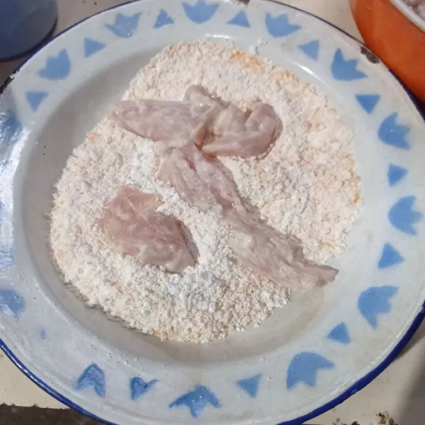 Campur tepung terigu, tepung bumbu dan tepung panir ke wadah aduk rata, lalu gulingkan ayam ke campuran tepung .