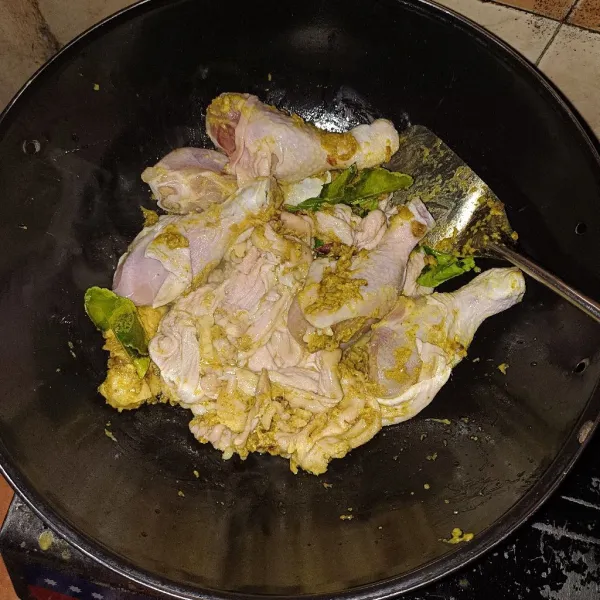 Setelah bumbu matang, masukkan ayam serta kulit, masak sampai ayam berubah warna.