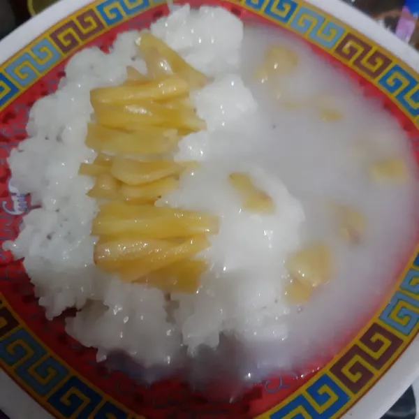 Ambil ketan kukus di piring saji, beri saus dan potongan nangka