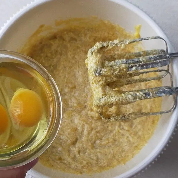 Tambahkan telur satu persatu bergantian dengan sebagian tepung terigu dan baking powder sambil di ayak.